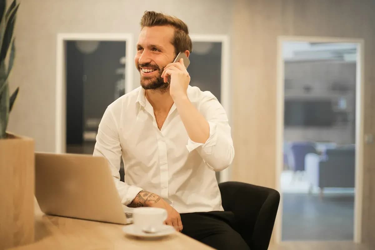 Two people talking through building plans over coffee